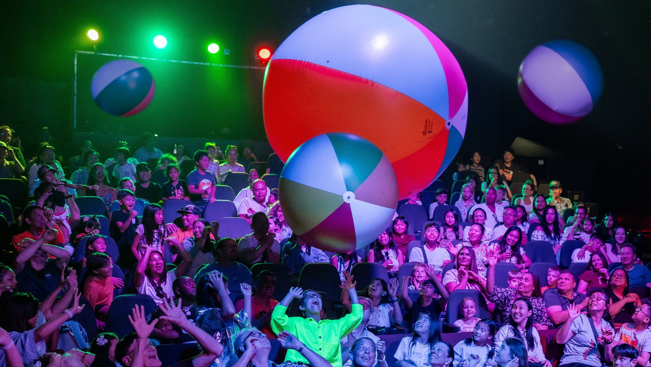 Giant beach balls above the laughing audience